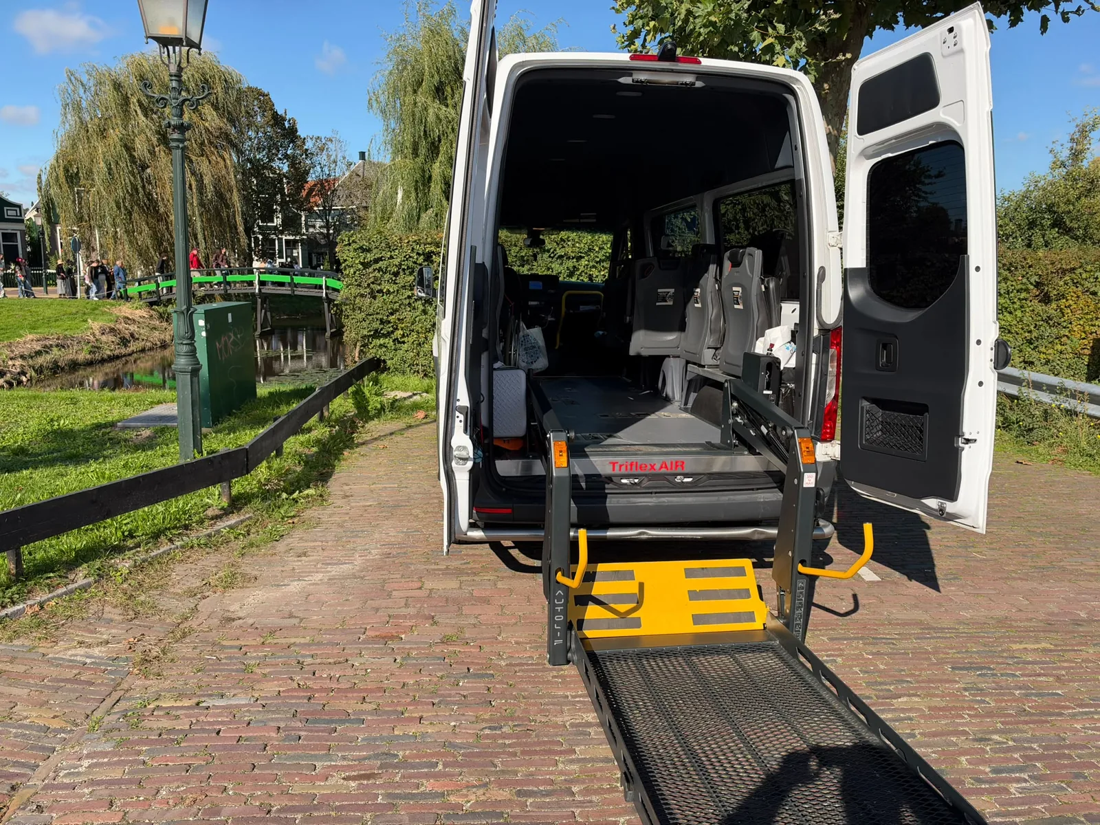 De uitgeklapte rolstoellift en de open achterzijde van onze bus